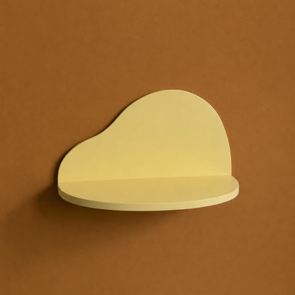 A minimalist, cloud-shaped wall shelf in a pale yellow color, mounted on a solid warm brown wall.